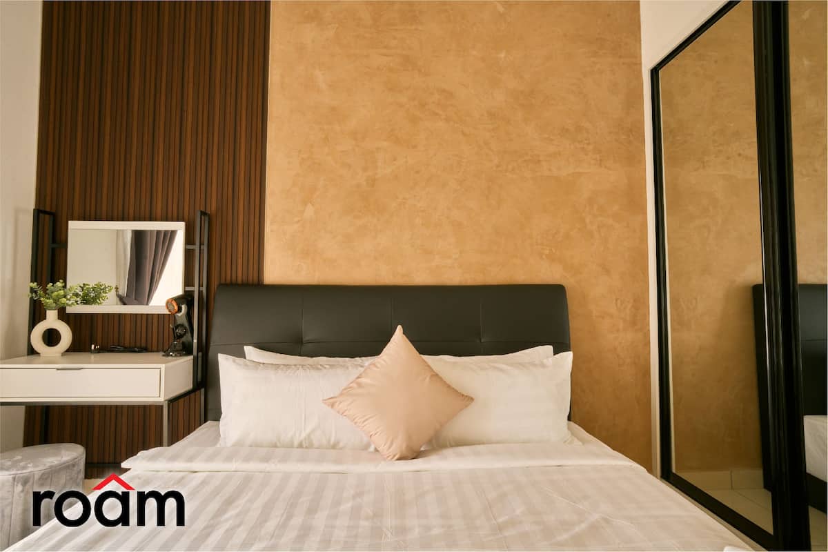 Une chambre à coucher moderne avec un grand lit, une table de chevet, un miroir et une armoire.