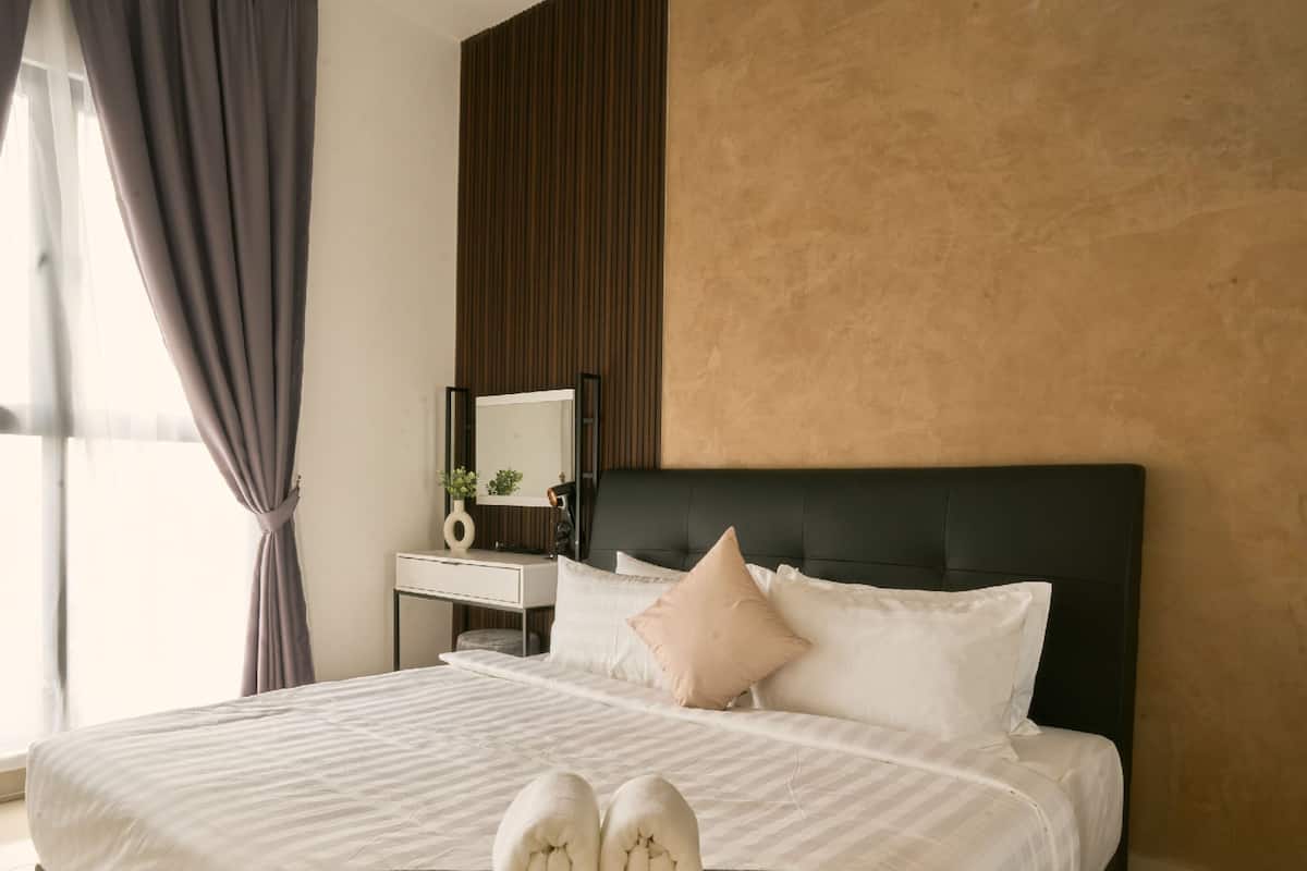 Une chambre d’hôtel avec un lit, une table de chevet, un miroir et une fenêtre avec des rideaux.