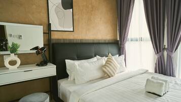 Quarto de hotel com cama, escrivaninha, cadeira, espelho e janela com cortinas.