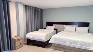 A hotel room with two beds, a wooden nightstand, and a small drawer unit. - The Freelancer Hotel (Pattaya)