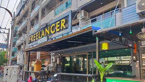 A building with a sign for 'Freelancer Hotel' and a sign for 'Indian Food'. - The Freelancer Hotel (Pattaya)