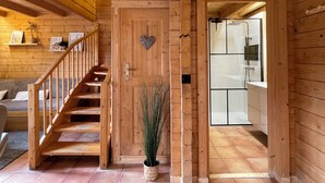 A wooden interior with a staircase, a heart-shaped decoration, and a potted plant.
