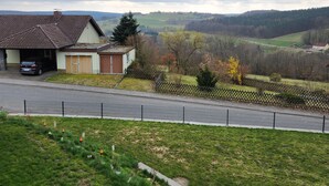 Un quartiere residenziale con case, una strada e un paesaggio collinare sullo sfondo.