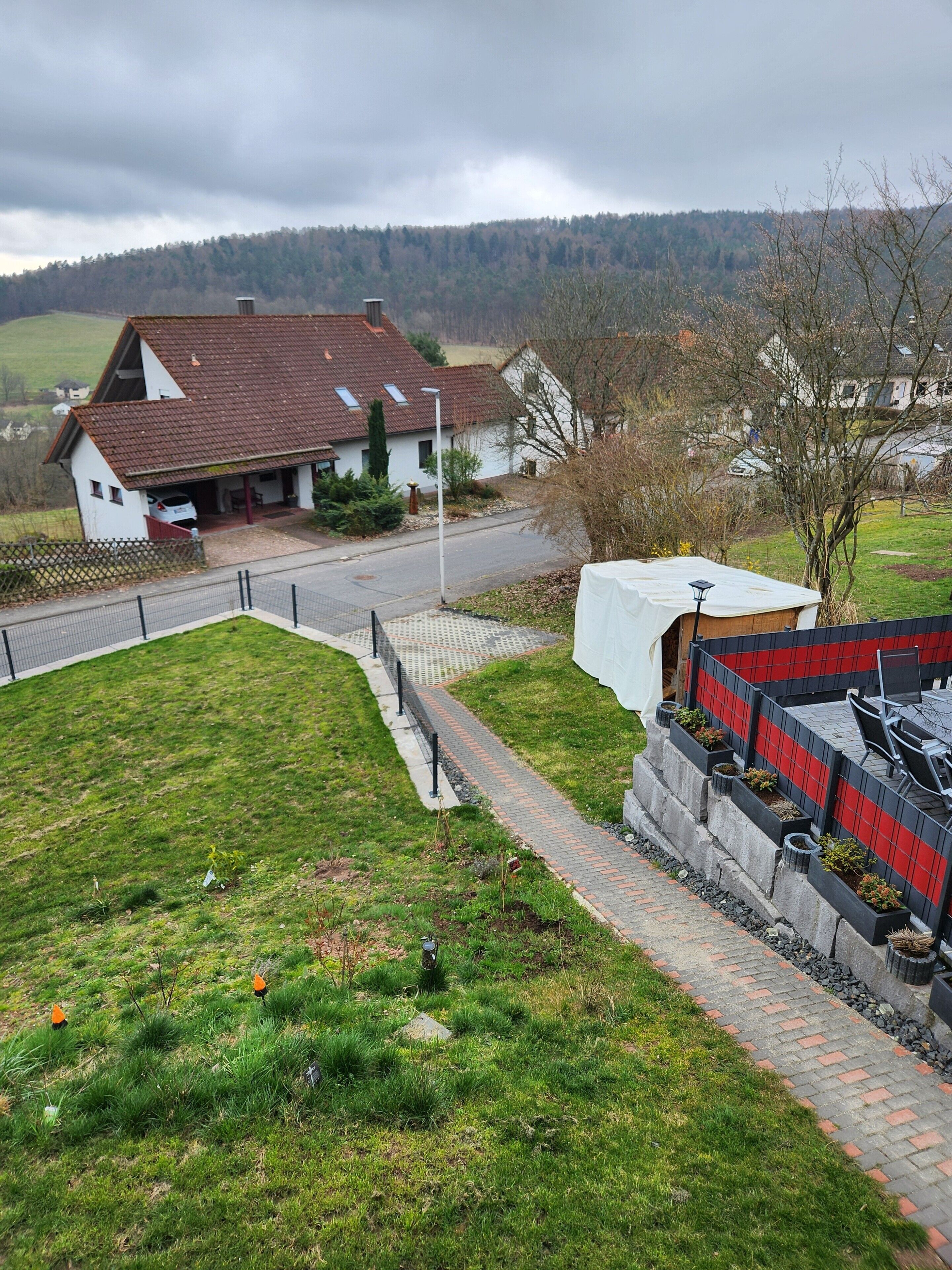 Ein Wohngebiet mit einem Haus, einer gepflasterten Auffahrt und einem Rasen.
