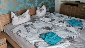 Una camera da letto con un letto, una testiera in legno, una parete decorata e un quadro appeso.