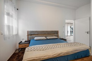 A bedroom with a bed, bedside table, lamp, and a view of a hallway. - Apartment 'City Villa Bad Dürrheim - Penthouse' with Balcony and Wi-Fi (Bad Dürrheim)