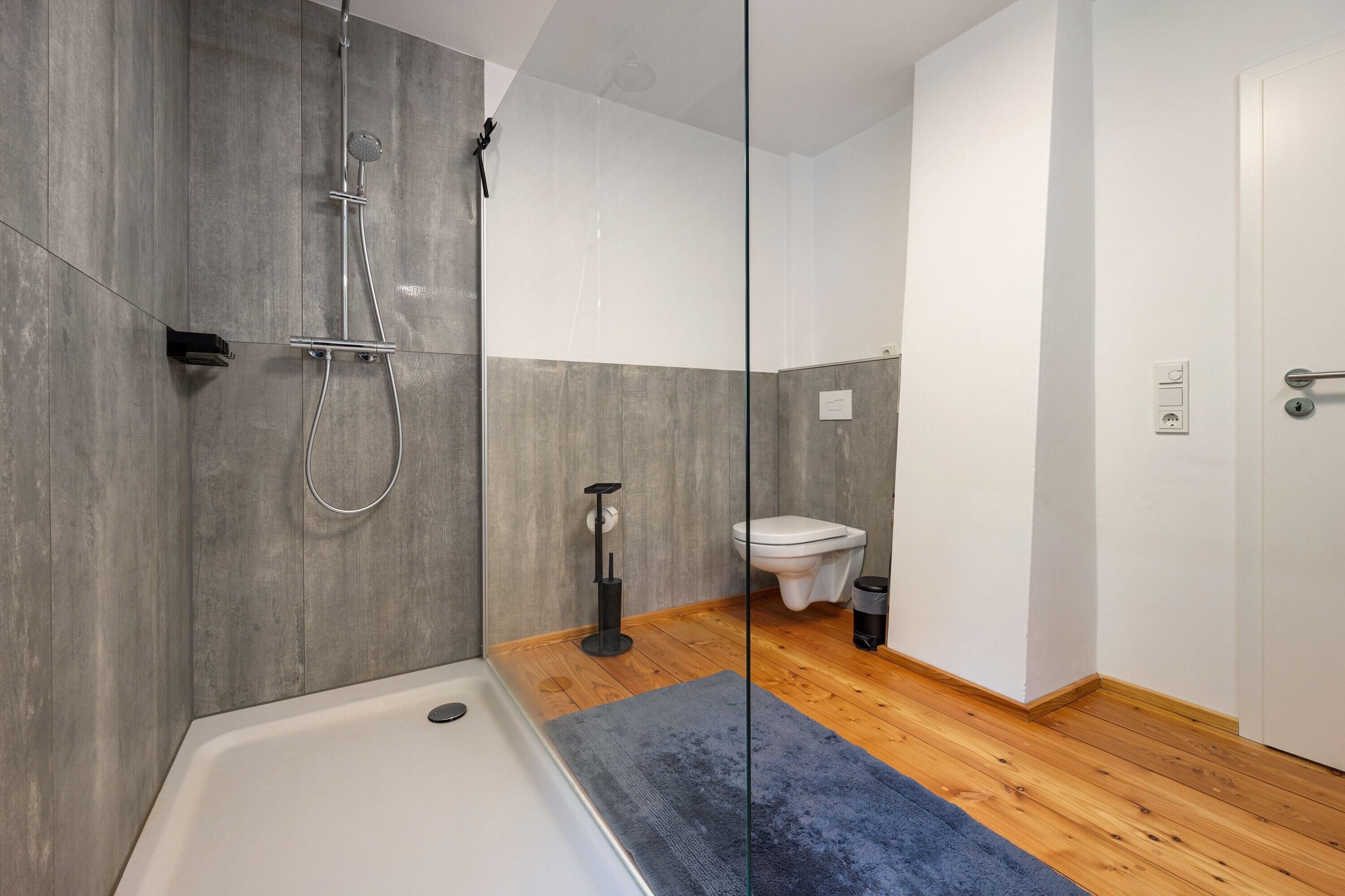 Et moderne badeværelse med bruser, toilet og badekar.