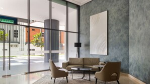 A modern lobby with a sofa and chairs, a large window, and a minimalist artwork on the wall. - Datum Jelatek Sky Residence Roam (Ampang)