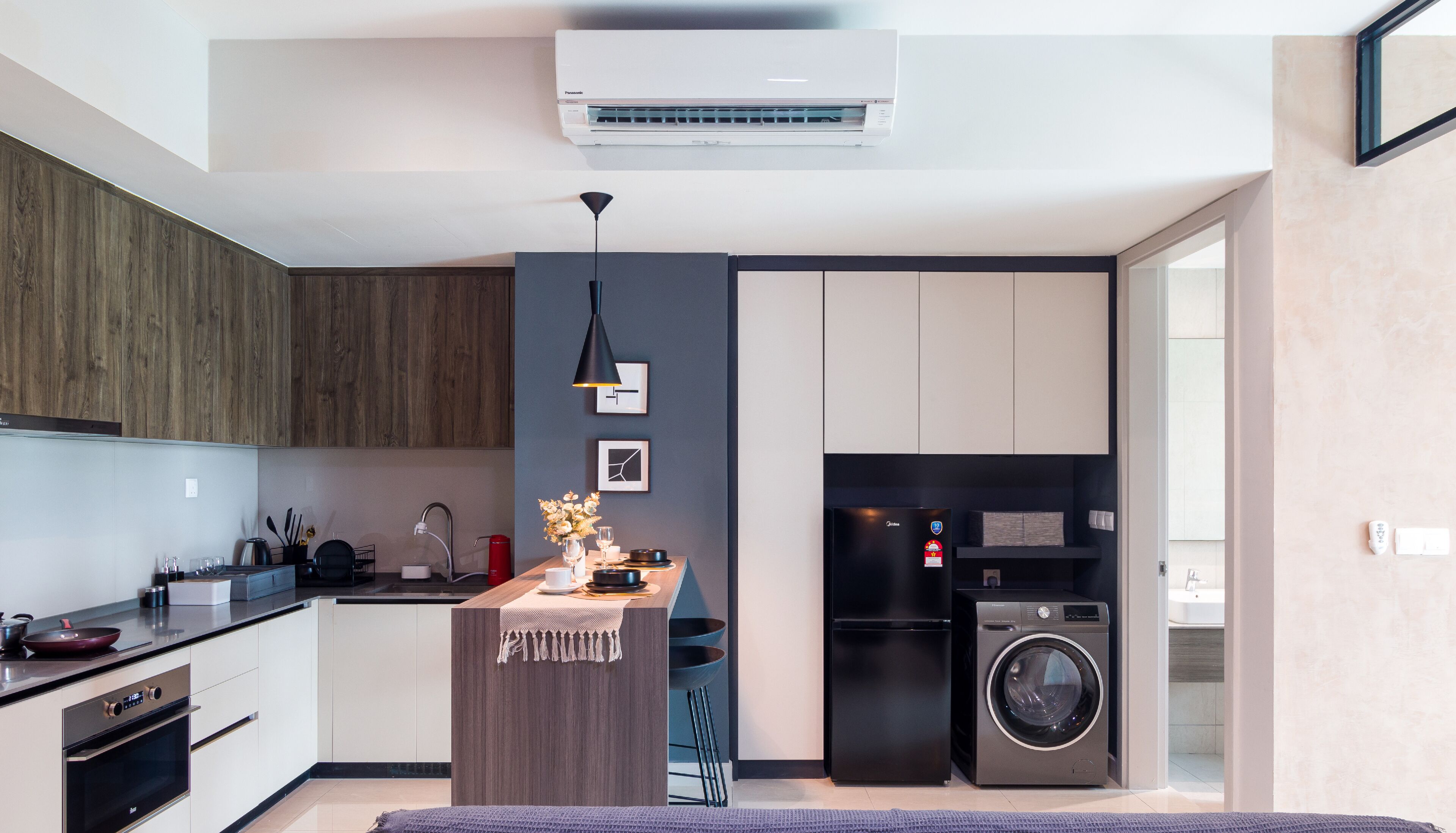 Una cocina moderna con una isla central, electrodomésticos integrados y una lavadora.