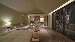 A modern hotel room with a large bed, a seating area, a kitchen, and a balcony with a view. - Jiangnan House Chaozhou (Chaozhou)