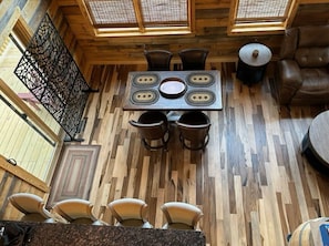 A wooden dining area with a table, chairs, and a large window.