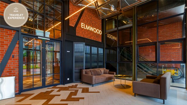 Een modern interieur met een bakstenen muur, glazen deuren en een bank.