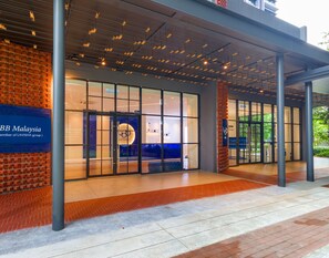 Een moderne entree van een gebouw met een bordes voor LBB Maleisië, onderdeel van de Lavisha groep.
