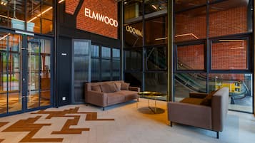 A modern interior with a brick wall, glass doors, and a sofa.