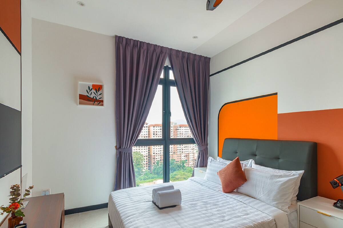 Une chambre d’hôtel moderne avec un grand lit, une table de chevet, un bureau et une fenêtre avec des rideaux.