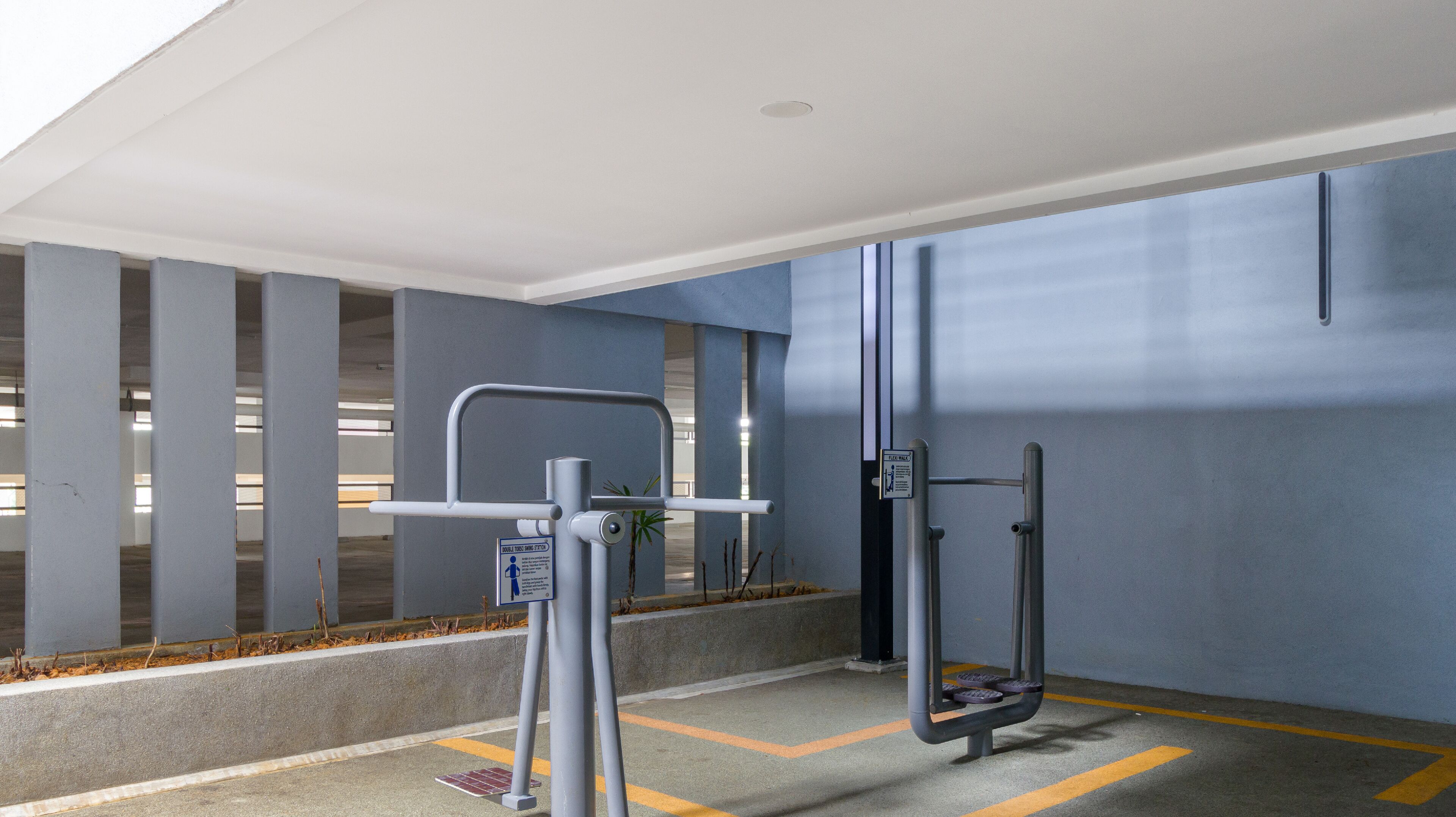 A clean, modern elevator area with a handrail, a button panel, and a sign indicating a lift for wheelchairs.
