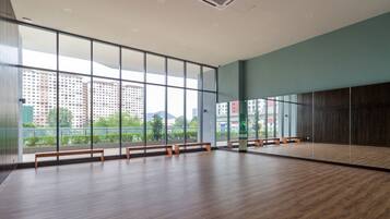 A spacious room with large windows, wooden benches, and a view of a cityscape.