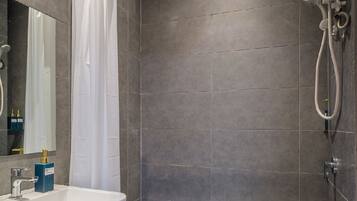 A modern bathroom with a shower, a sink, and a mirror.