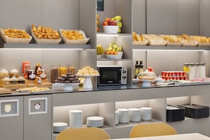 A buffet with various food items, including pastries, fruits, and condiments. - B&B Hotel Lleida  (Lleida)