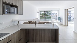Cuina moderna amb microones integrat, armaris de fusta i una finestra gran que ofereix vistes a l'exterior.