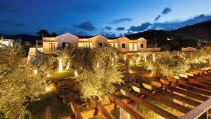 A modern hotel with multiple guest rooms, a well-lit garden, and a wooden pergola. - The Yard Corfu  (Corfu)