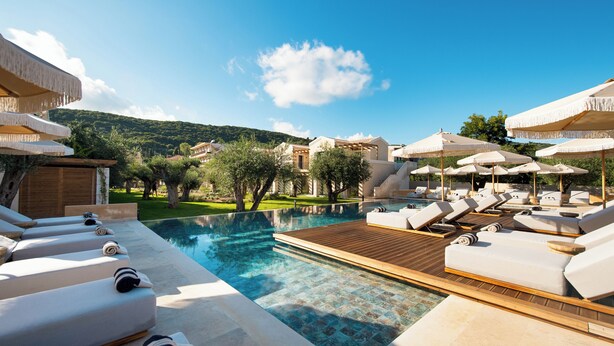 A poolside area with sun loungers, umbrellas, and a wooden deck. - The Yard Corfu  (Corfu)