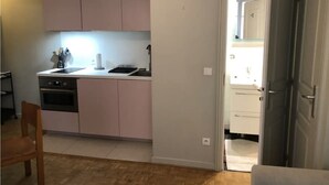 Una cocina compacta con horno integrado, un lavamanos y una encimera.