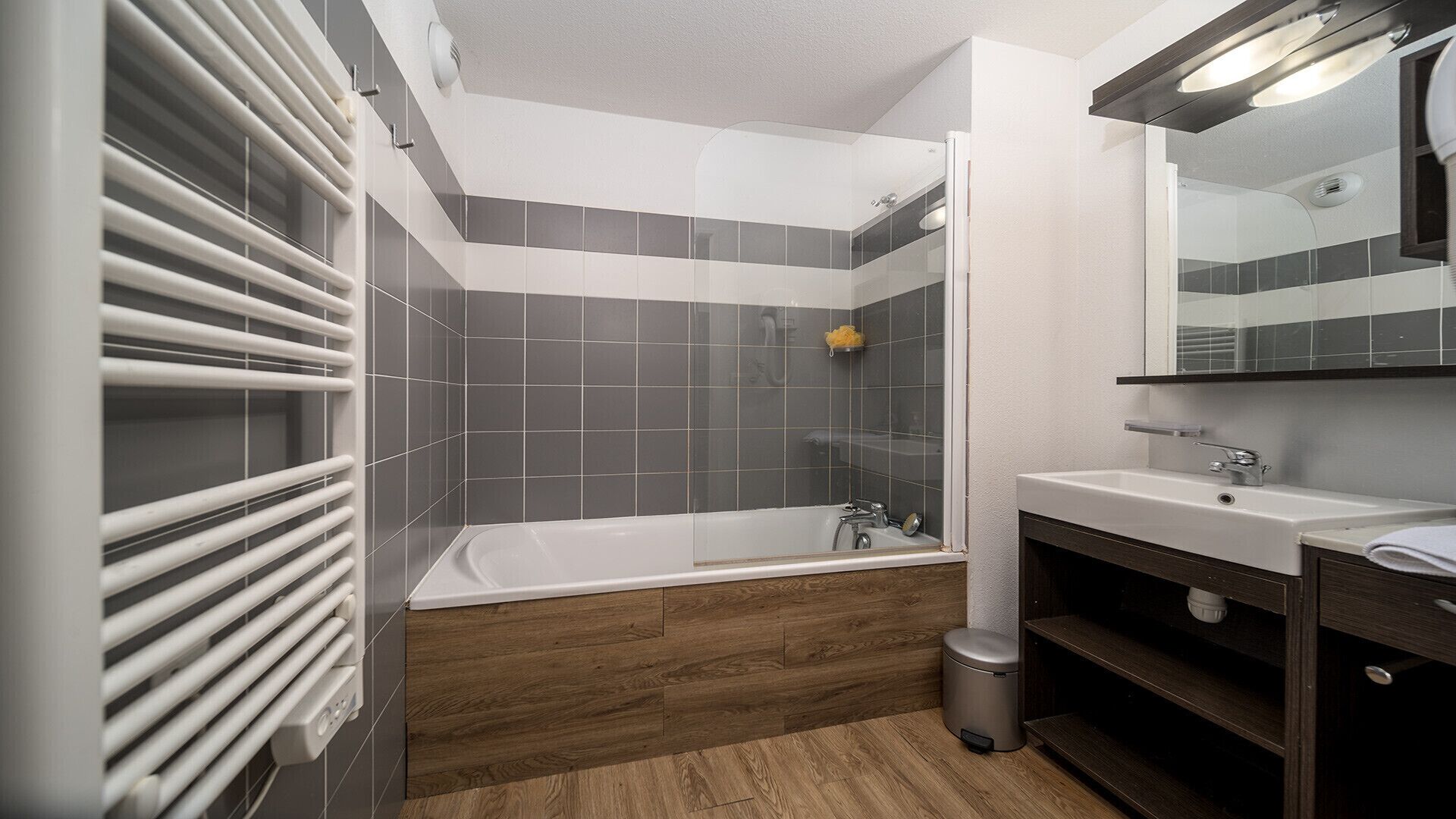 A modern bathroom with a bathtub, a shower, and a vanity with a mirror.