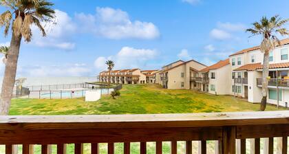 Waterfront condo with bay view, outdoor pool, tennis, dock, balcony, W/D, & AC