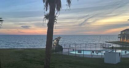 Waterfront condo with bay view, outdoor pool, tennis, dock, balcony, W/D, & AC