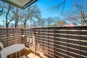 A patio area with a wooden fence, a white table, and chairs. - I52 - Apt|Patio|11mi to Convention Ctr|Sleeps 2 (Irving)
