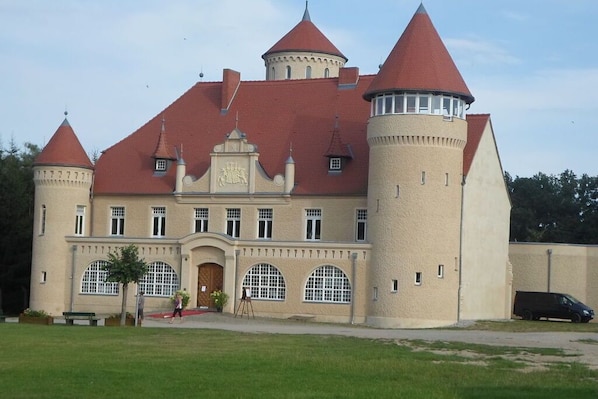 A castle-like building with multiple towers and arched windows.