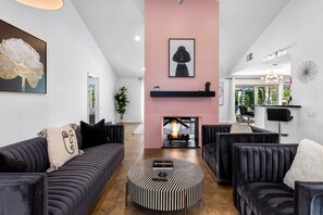 A modern living room with a fireplace, sofas, and a coffee table. - Palm Springs Paradise (Palm Springs)