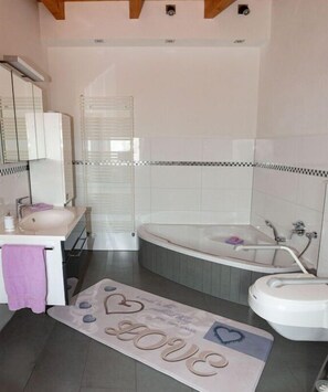 A bathroom with a bathtub, a sink, and a vanity.