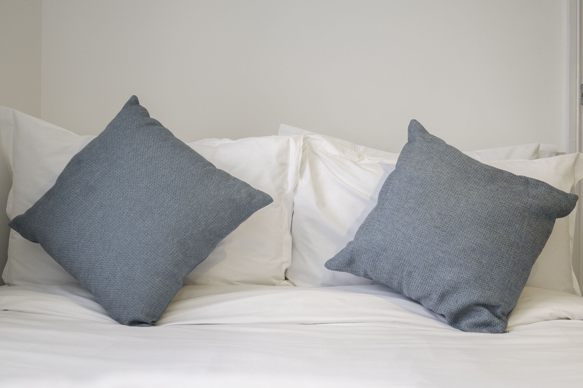 A bed with two pillows and a white duvet.