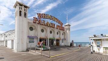 A seaside boardwalk with a prominent building labeled "Brighton Palace Pier."