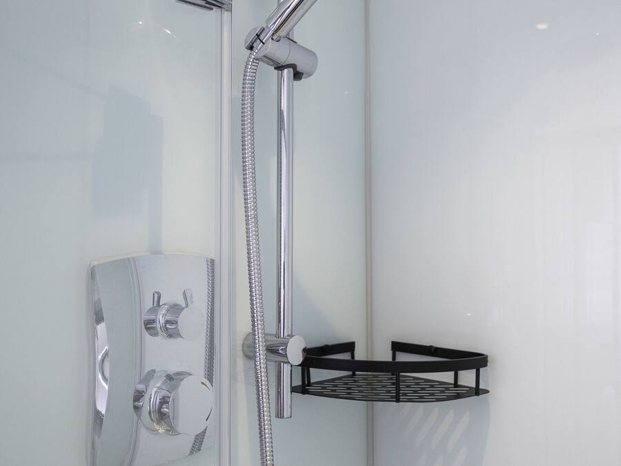 Um chuveiro moderno com chuveiro manual e painel de controle fixado na parede.
