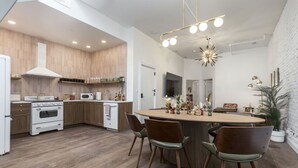 Une cuisine moderne avec des meubles en bois, un îlot central et un coin repas avec des chaises.