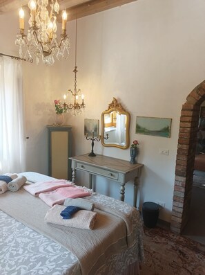 A bedroom with a bed, a dresser, a mirror, and a chandelier. - Spectacular 360-degree views of the sea and mountains. (caccamo)