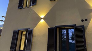 Un immeuble à plusieurs étages, doté de trois fenêtres, chacune ornée de volets noirs.