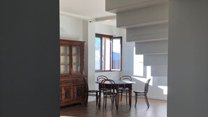 Une pièce spacieuse comprenant un coin repas avec un buffet en bois et une table entourée de chaises.