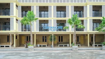 Een meerhoog hotel met balkons, palmbomen en een bord met de tekst 'CENTARALIFE LAMAI RESORT SAMUI'.