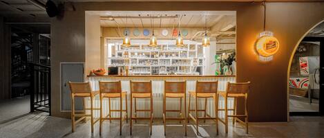 A bar area with wooden chairs, a counter, and a Miller Brewing sign.