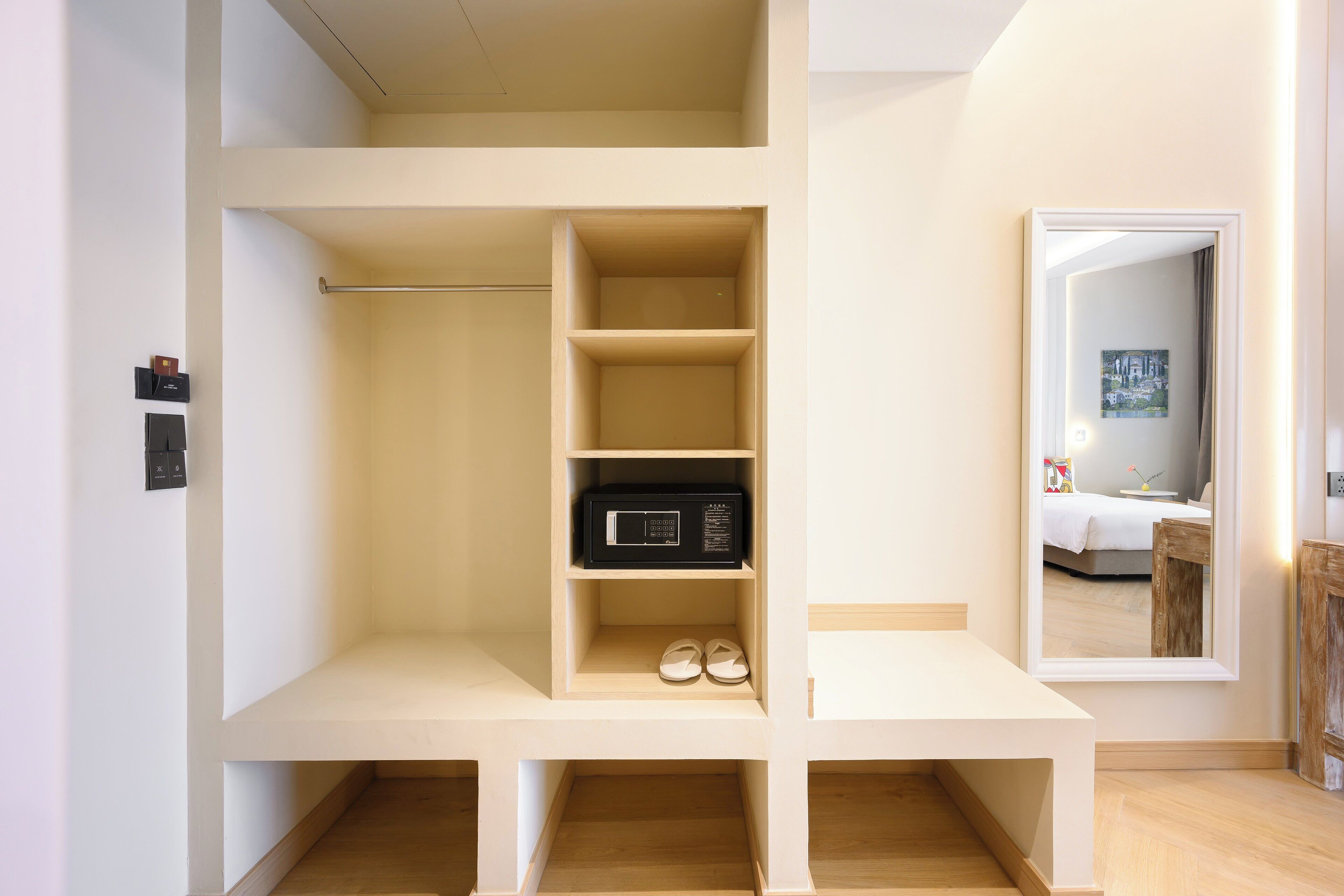 A modern, minimalist room with built-in shelving, a microwave, and a pair of shoes on the lower shelf.
