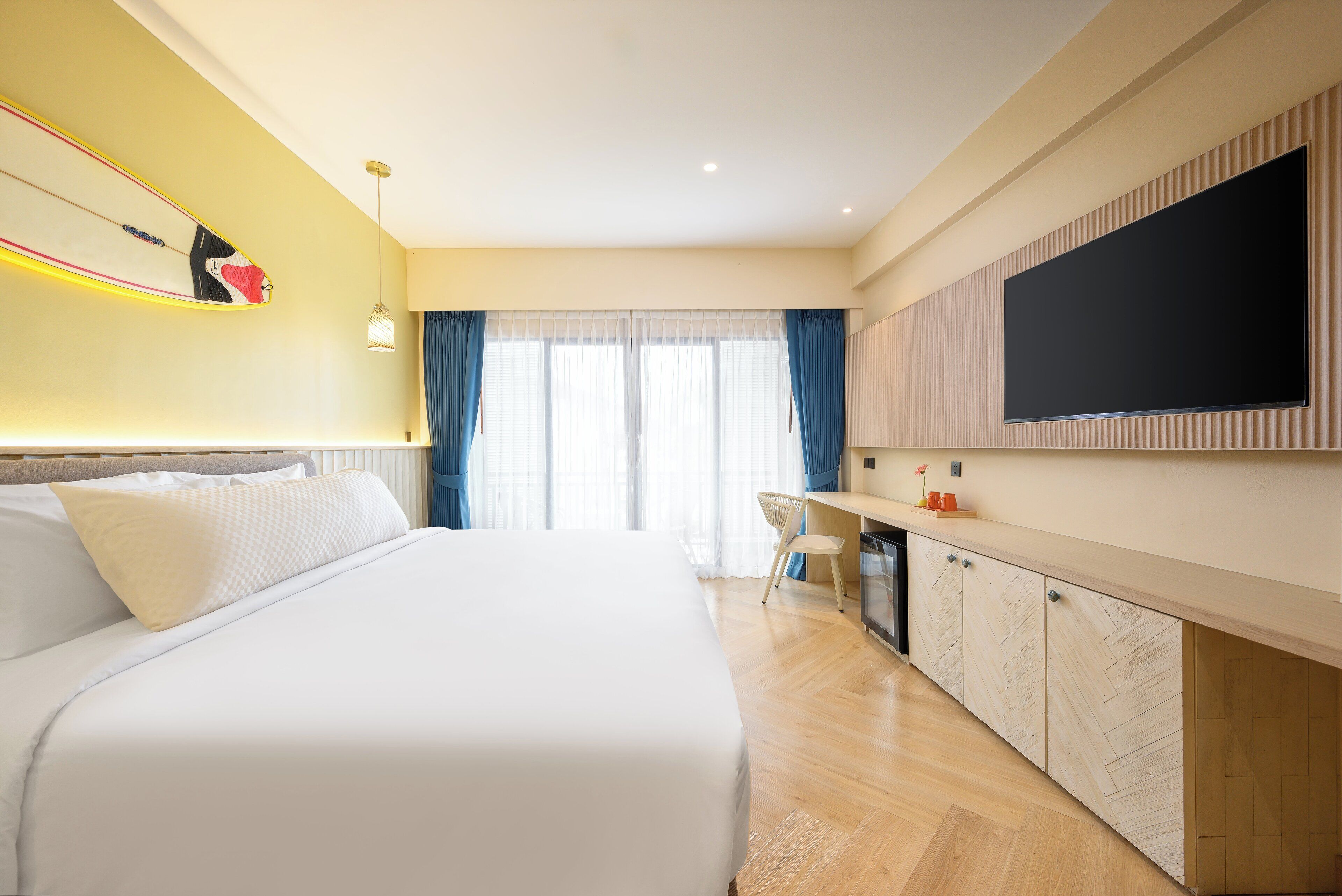 Een moderne hotelkamer met een groot bed, een bureau en een flatscreen televisie.