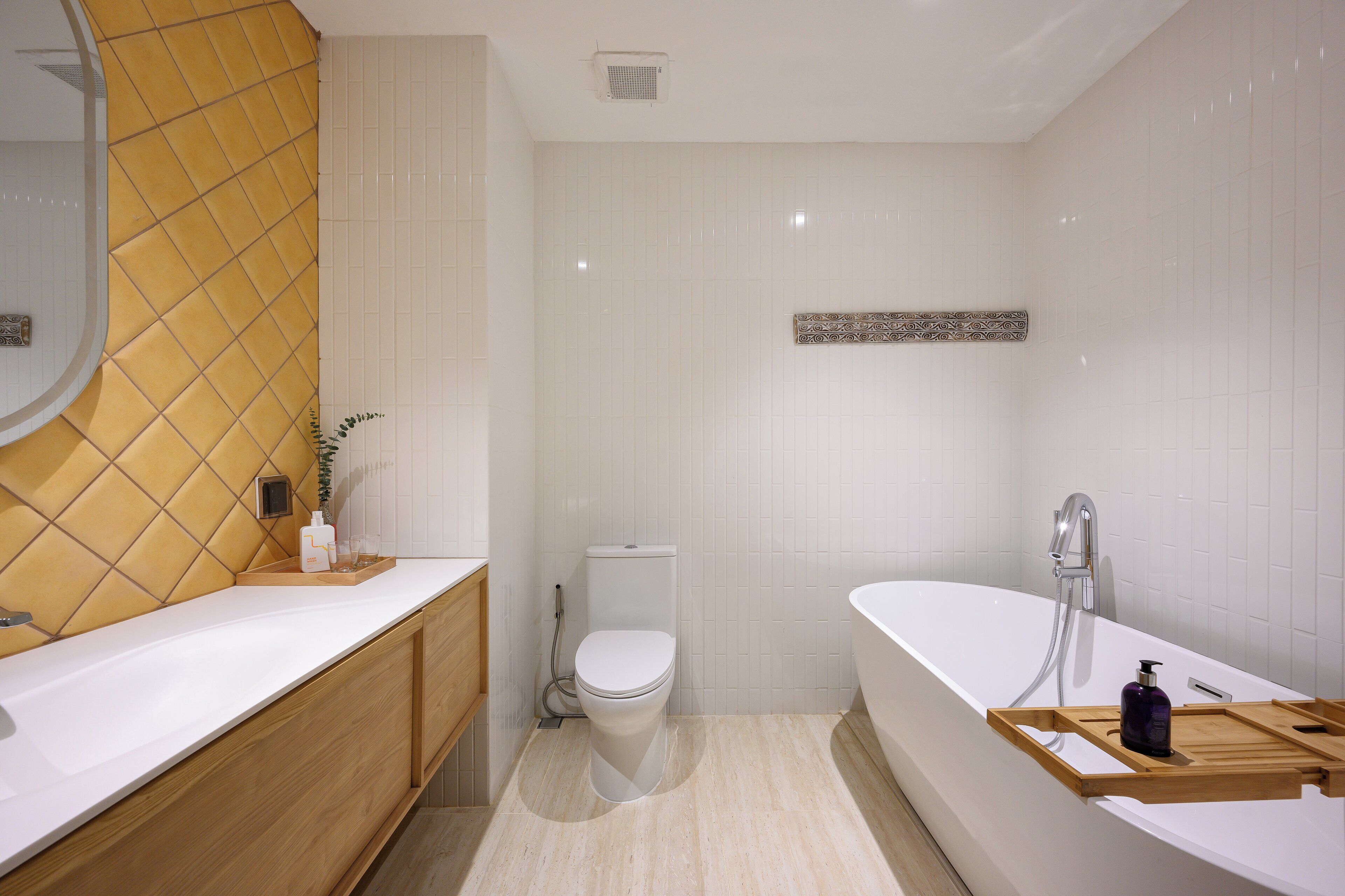 Une salle de bain moderne avec un lavabo, des toilettes et une baignoire, le tout de couleur blanche.