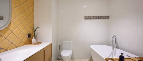 Une salle de bain moderne avec un lavabo, des toilettes et une baignoire, le tout de couleur blanche.