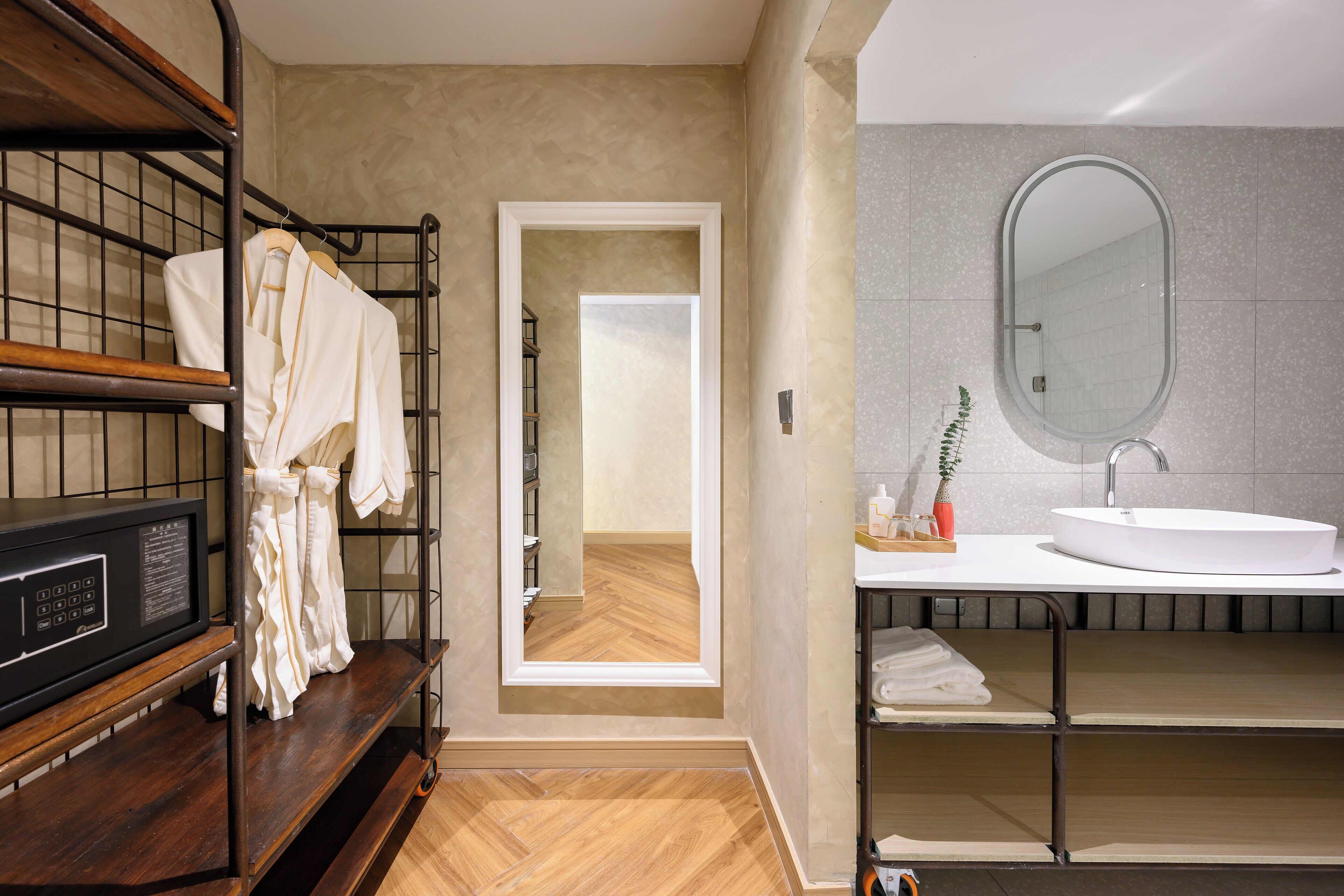 A modern bathroom with a wooden shelf, a white sink, and a mirror.