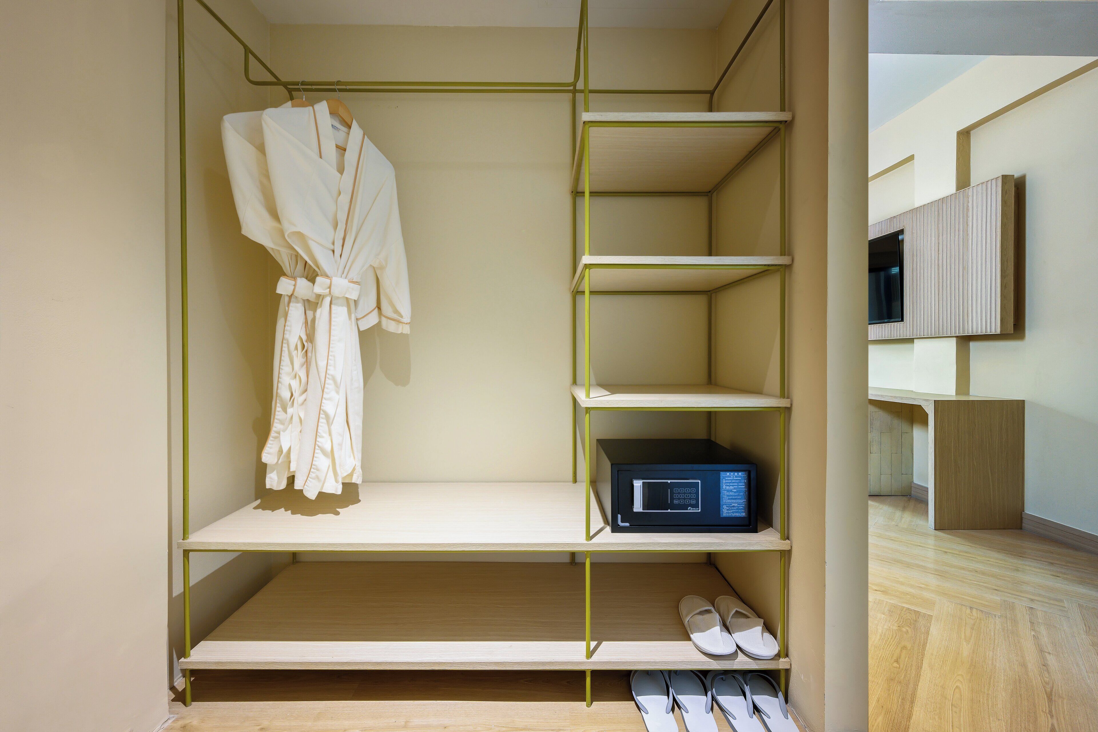 A walk-in closet with shelves, a robe, a microwave, and a pair of slippers.