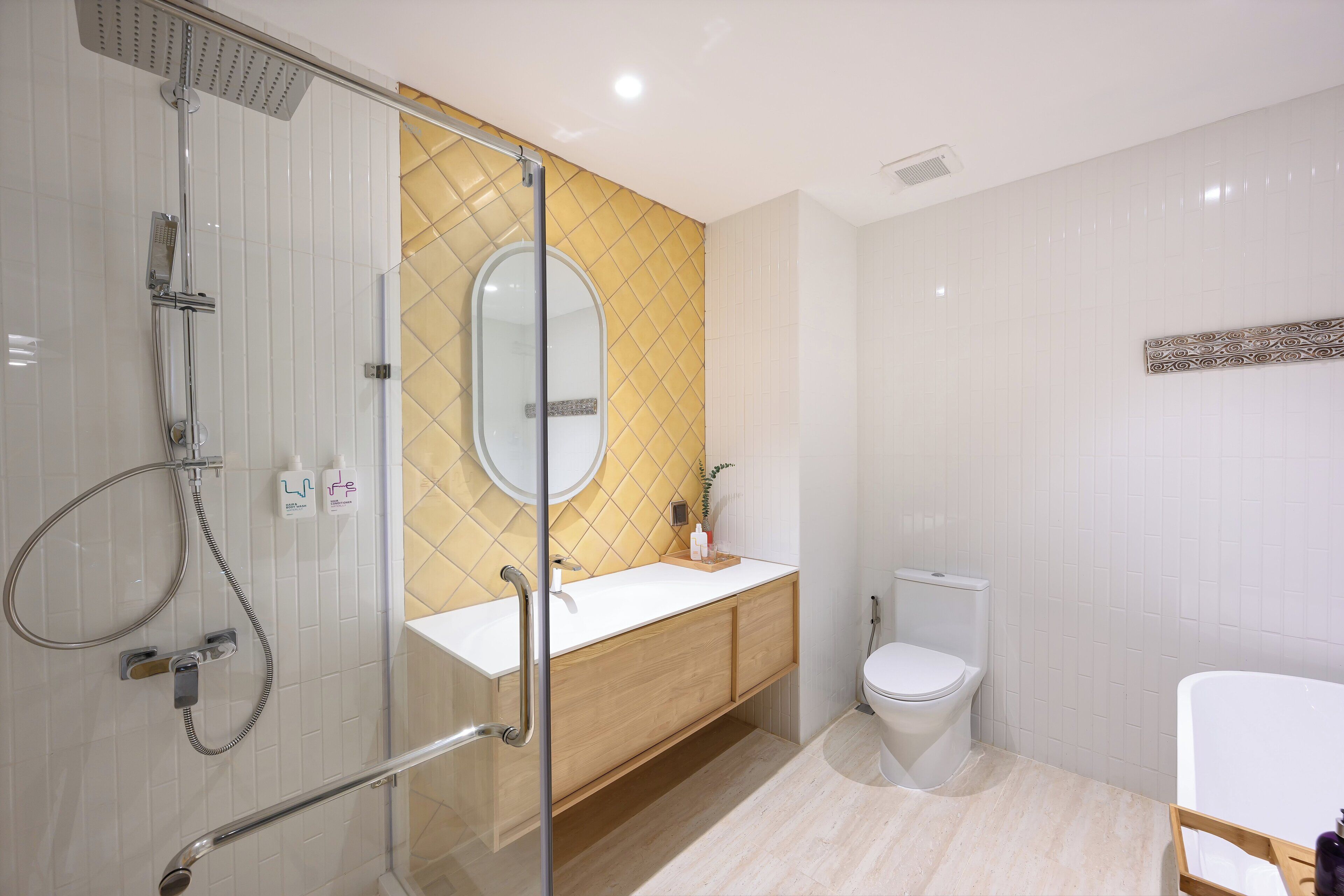 A modern bathroom with a glass shower enclosure, a white sink, a toilet, and a vanity with a mirror.